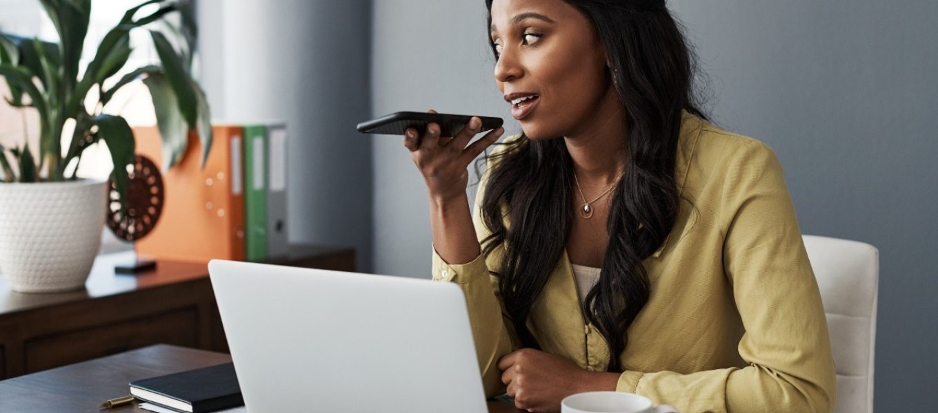 Brown-haired businesswoman voice-typing her ideas into notes