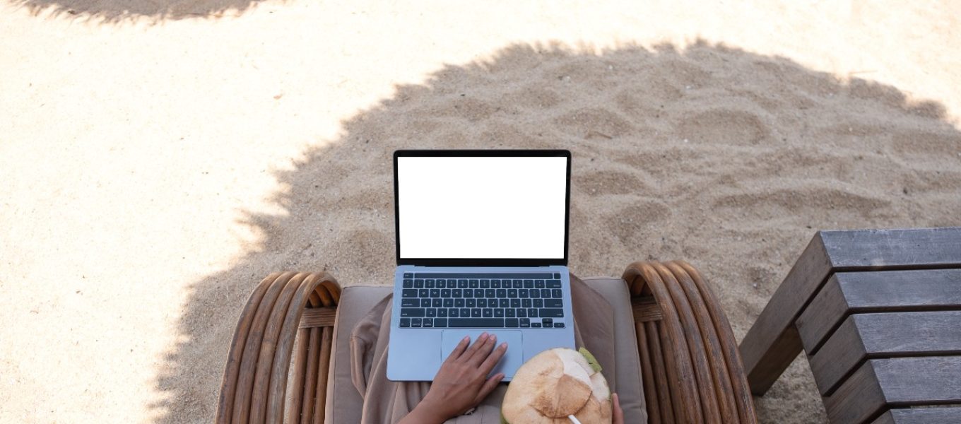 Lady sitting at the beach while doing remote job