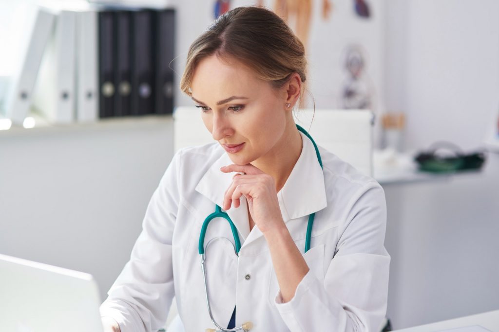 Doctora usando su portátil para transcribir lo que habla con sus pacientes