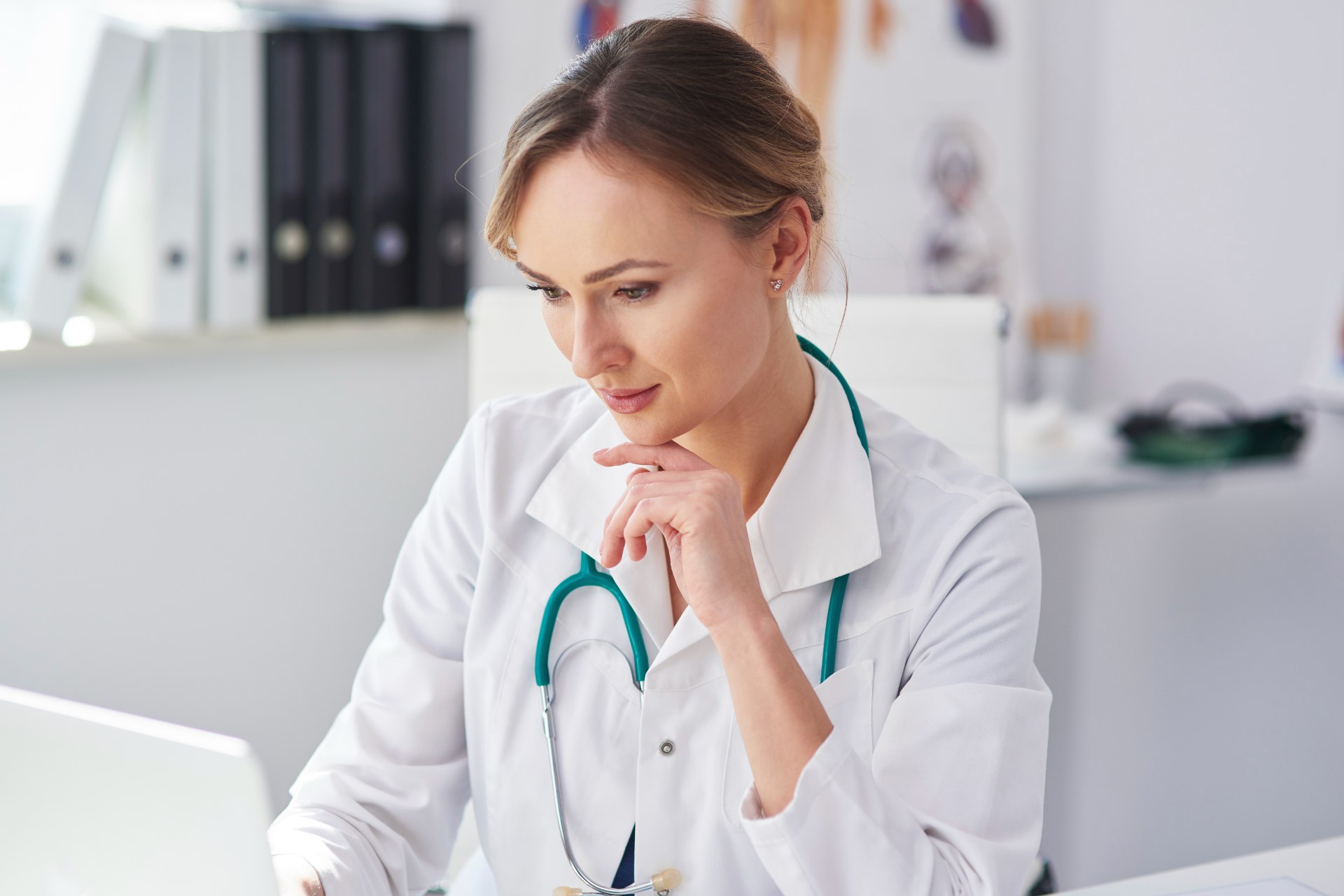 Doctora usando su portátil para transcribir lo que habla con sus pacientes