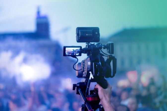 Gran cámara grabando un acto multitudinario al amanecer en el exterior
