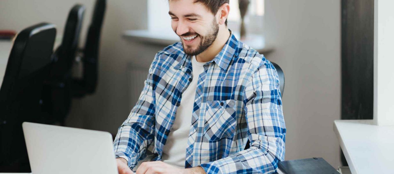 Hombre feliz trabajando en su portátil