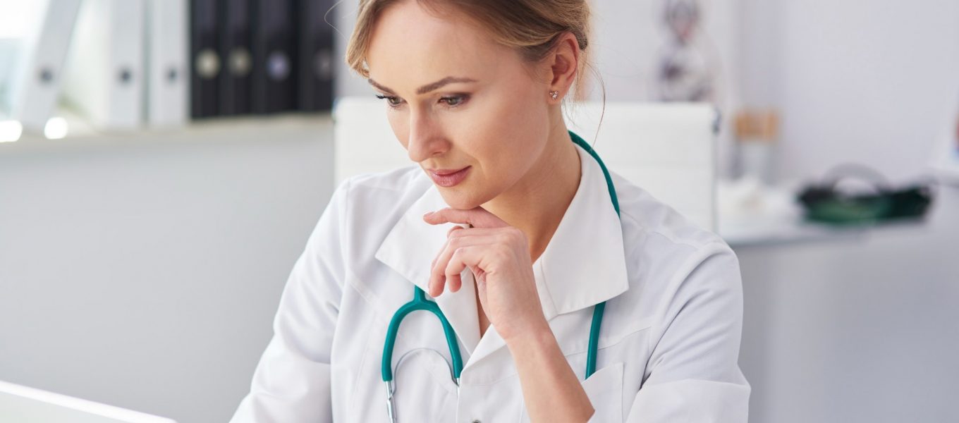 Doctora usando su portátil para transcribir lo que habla con sus pacientes